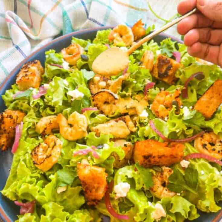 finished recipe served on a blue plate with dressing on the side.