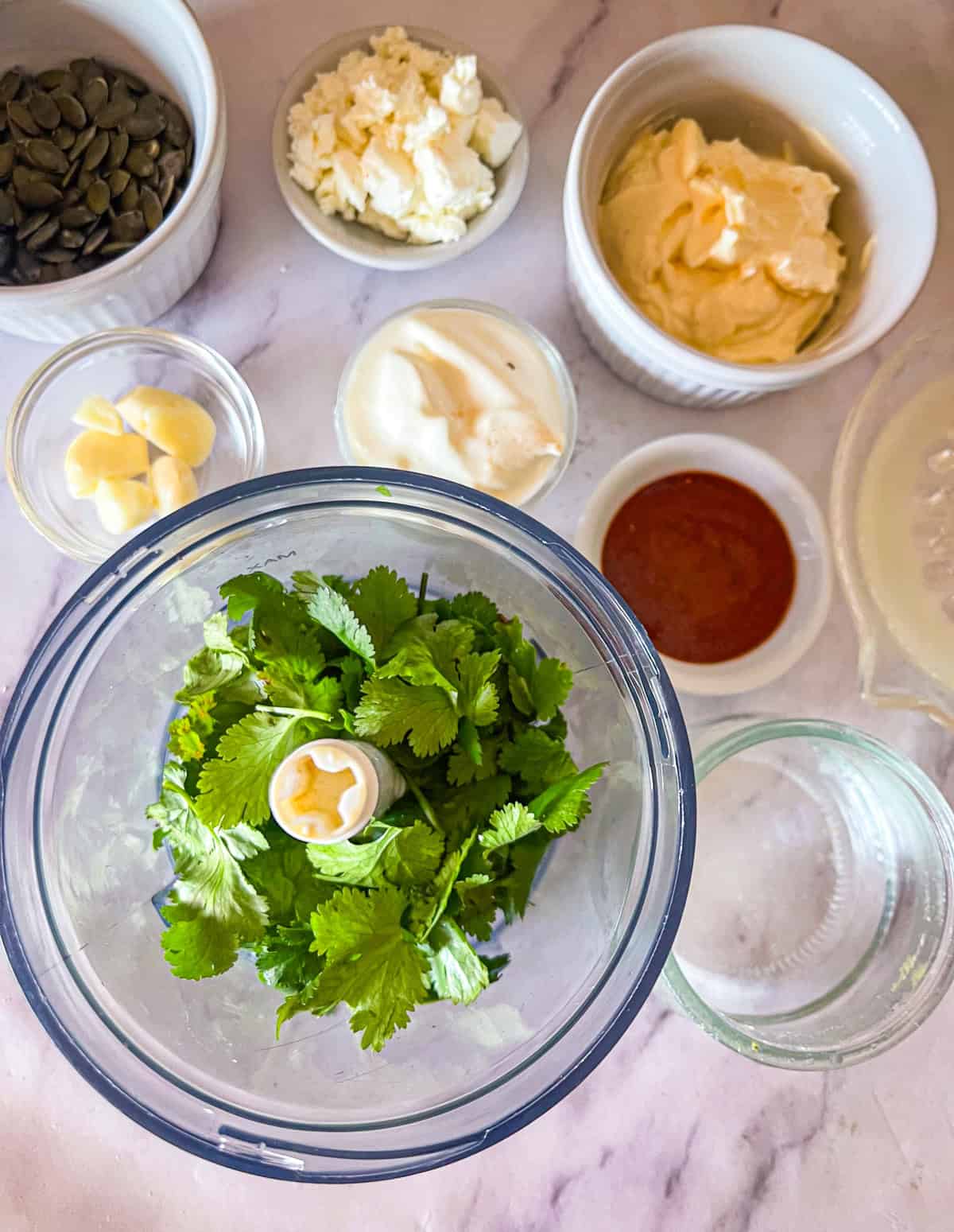 ingredients for dressing going into the food processor.