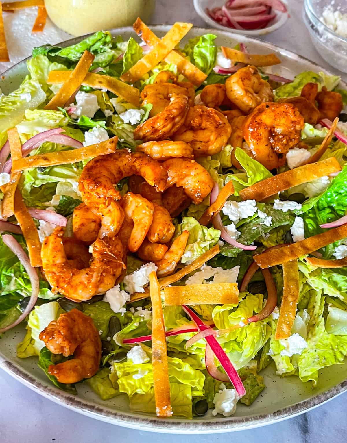 Finished salad topped with sweet and spicy shrimp.