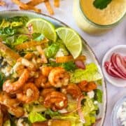 Mexican Salad with Shrimp garnished with lime wedges.