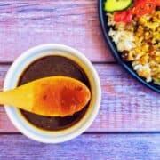 brown sauce in a white bowl with a spoon