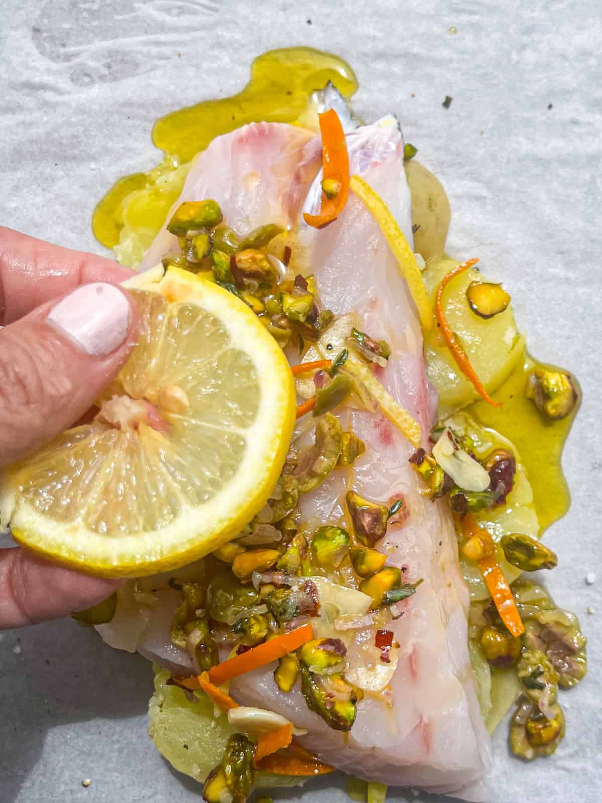 adding lemon to top of fish.