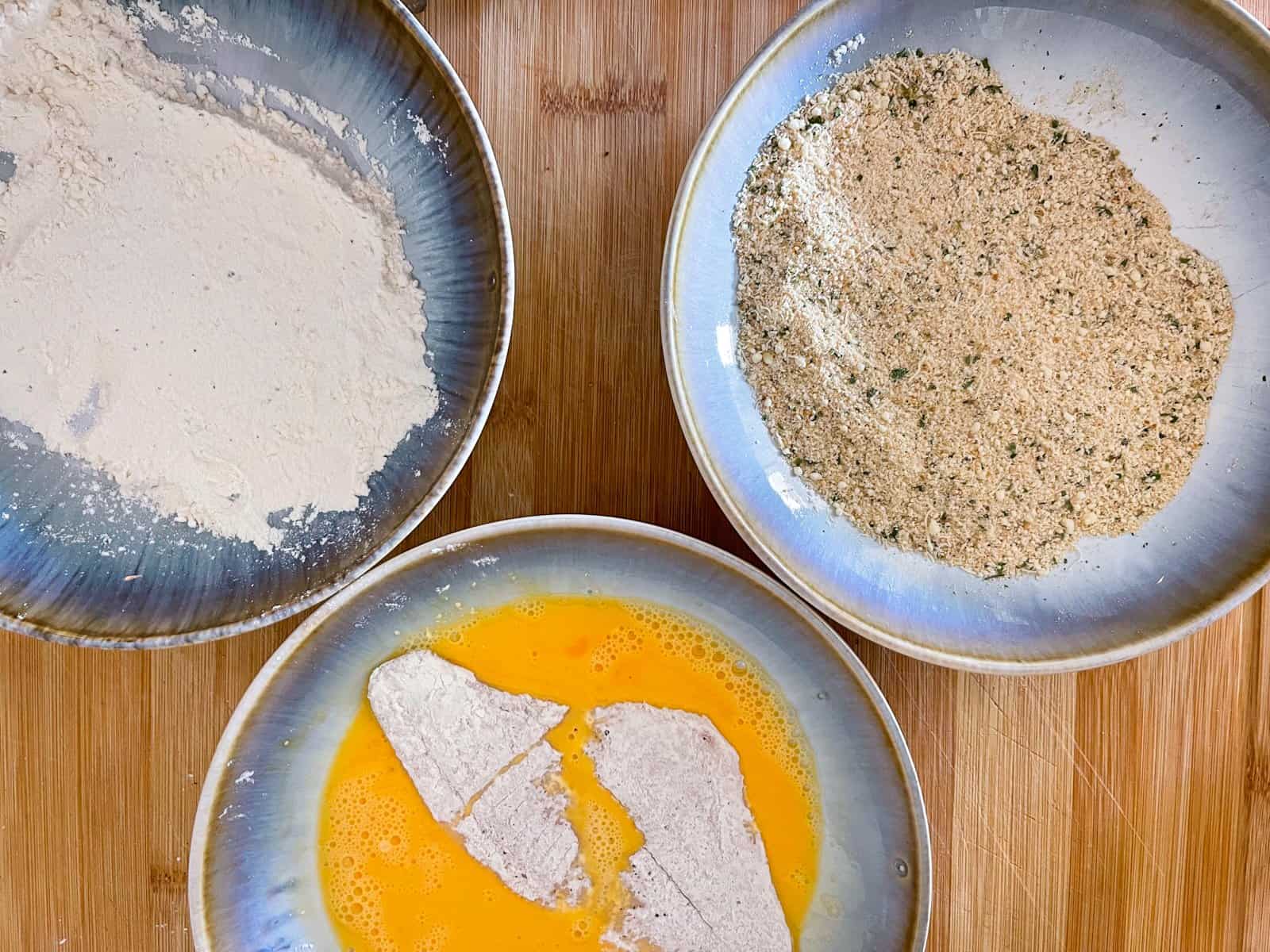 dredging fish fillet in flour, egg, then breadcrumbs.