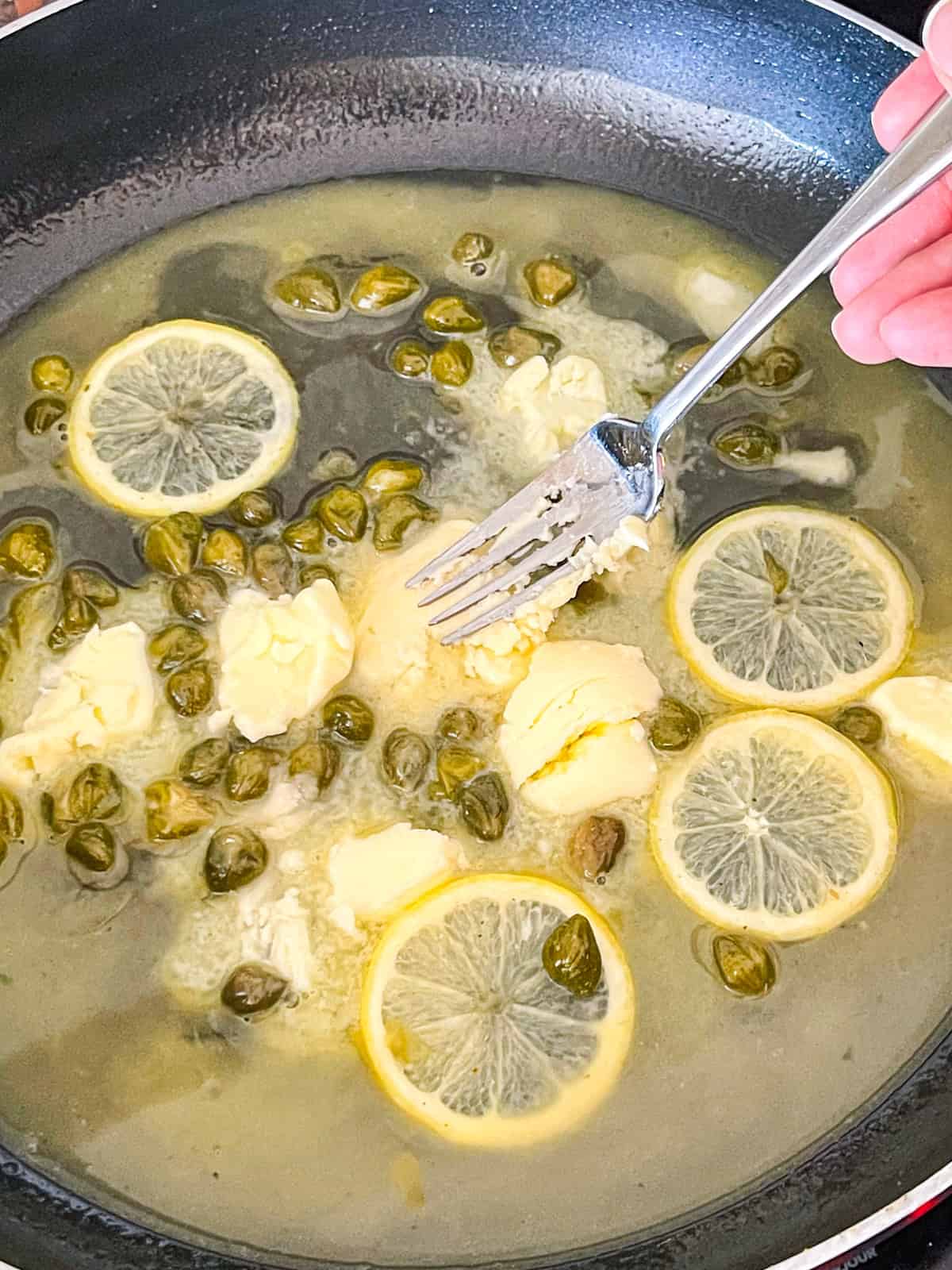 adding butter to sauce in skillet.