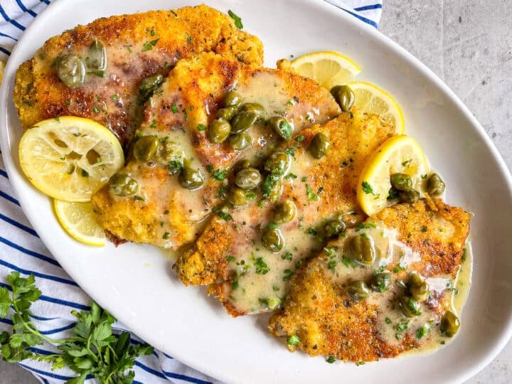 platter of crispy fish fillets drenched in lemon caper piccata sauce.