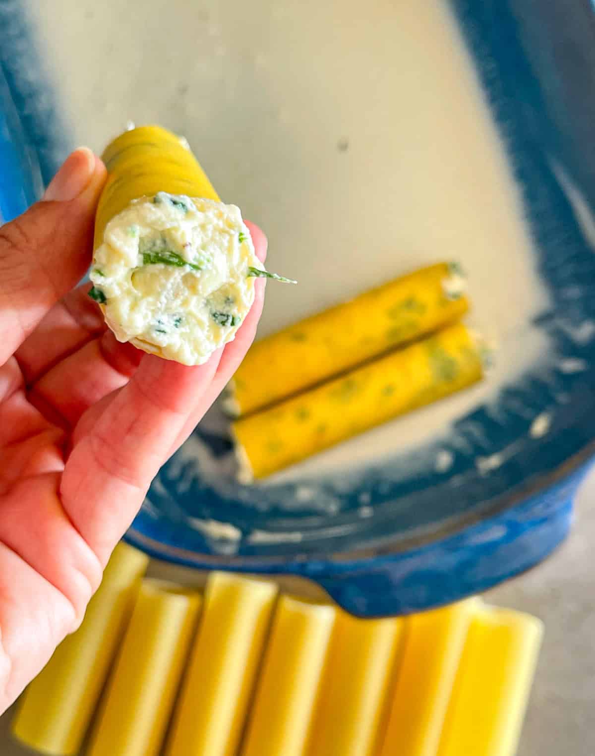 filled cannelloni shells sitting in a casserole dish.