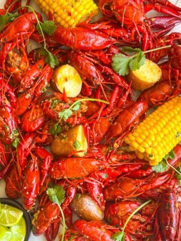 crawfish boil scattered across a table garnished with lime wedges.