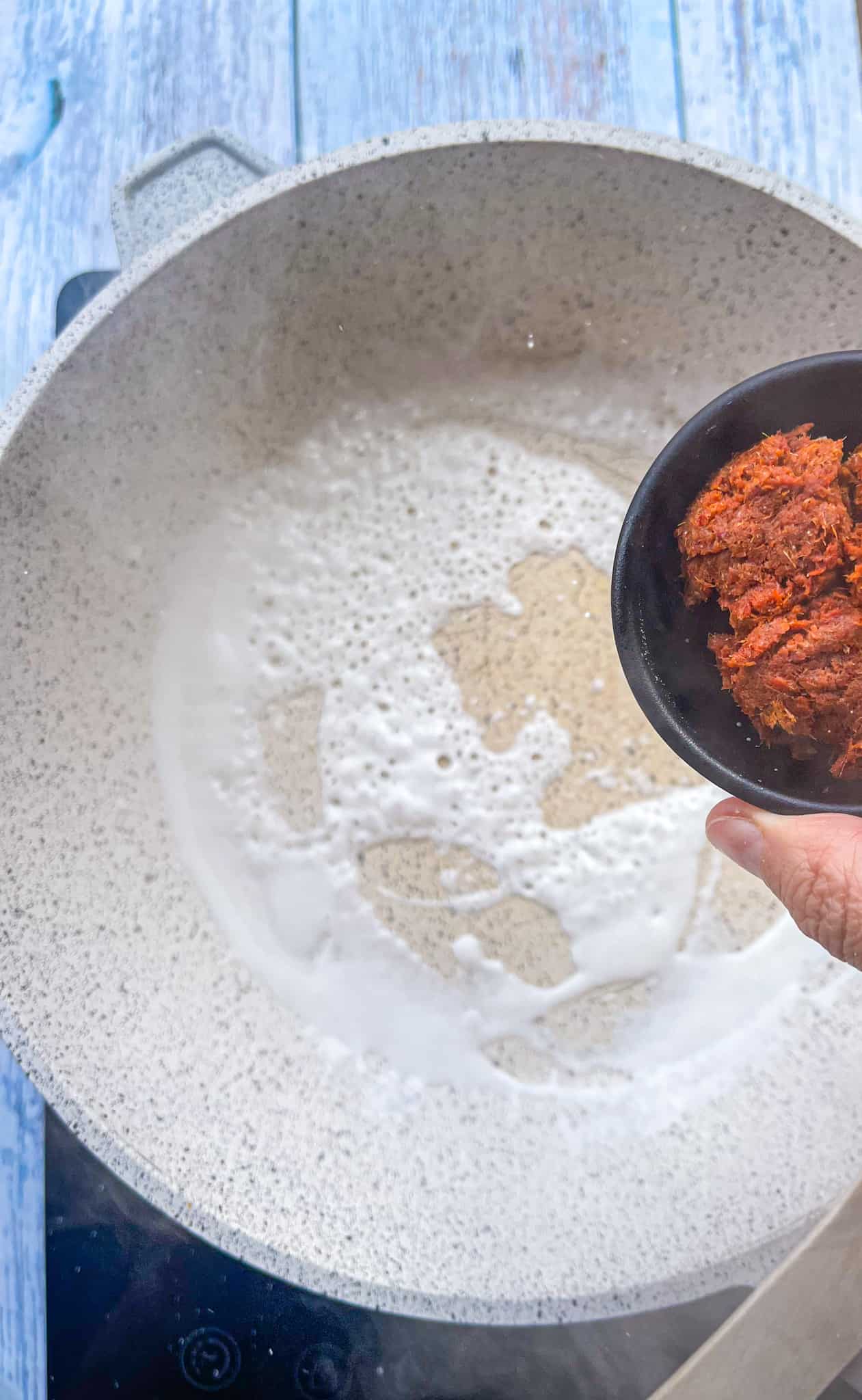 curry paste over a pan with sizzling coconut milk.