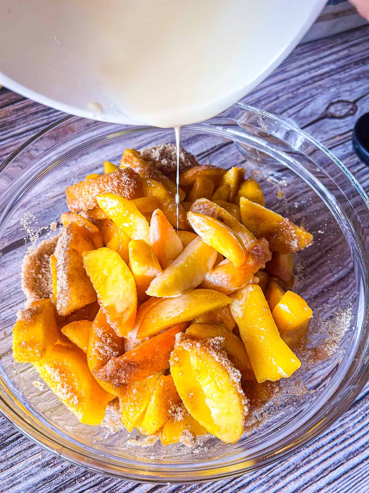 vanilla cornstarch mix poured over peaches in a bowl