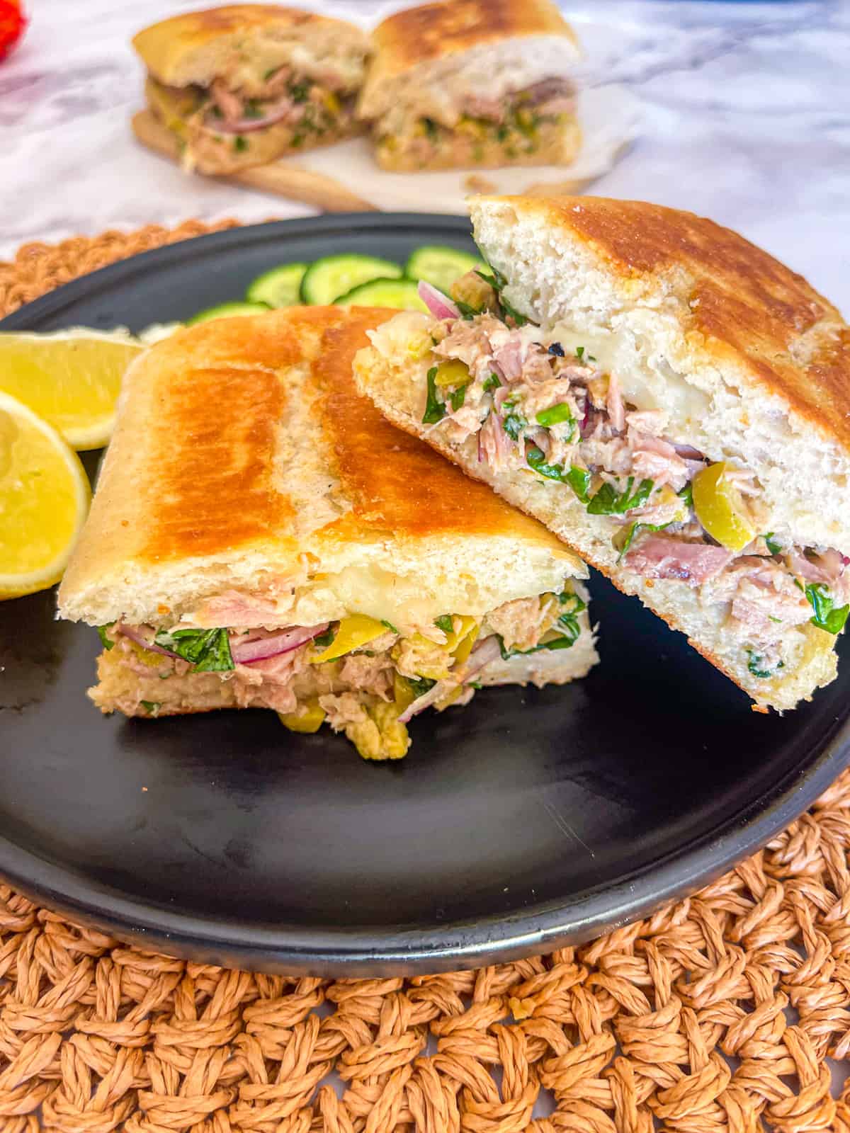 grilled sandwich on a plate served with lemon wedges