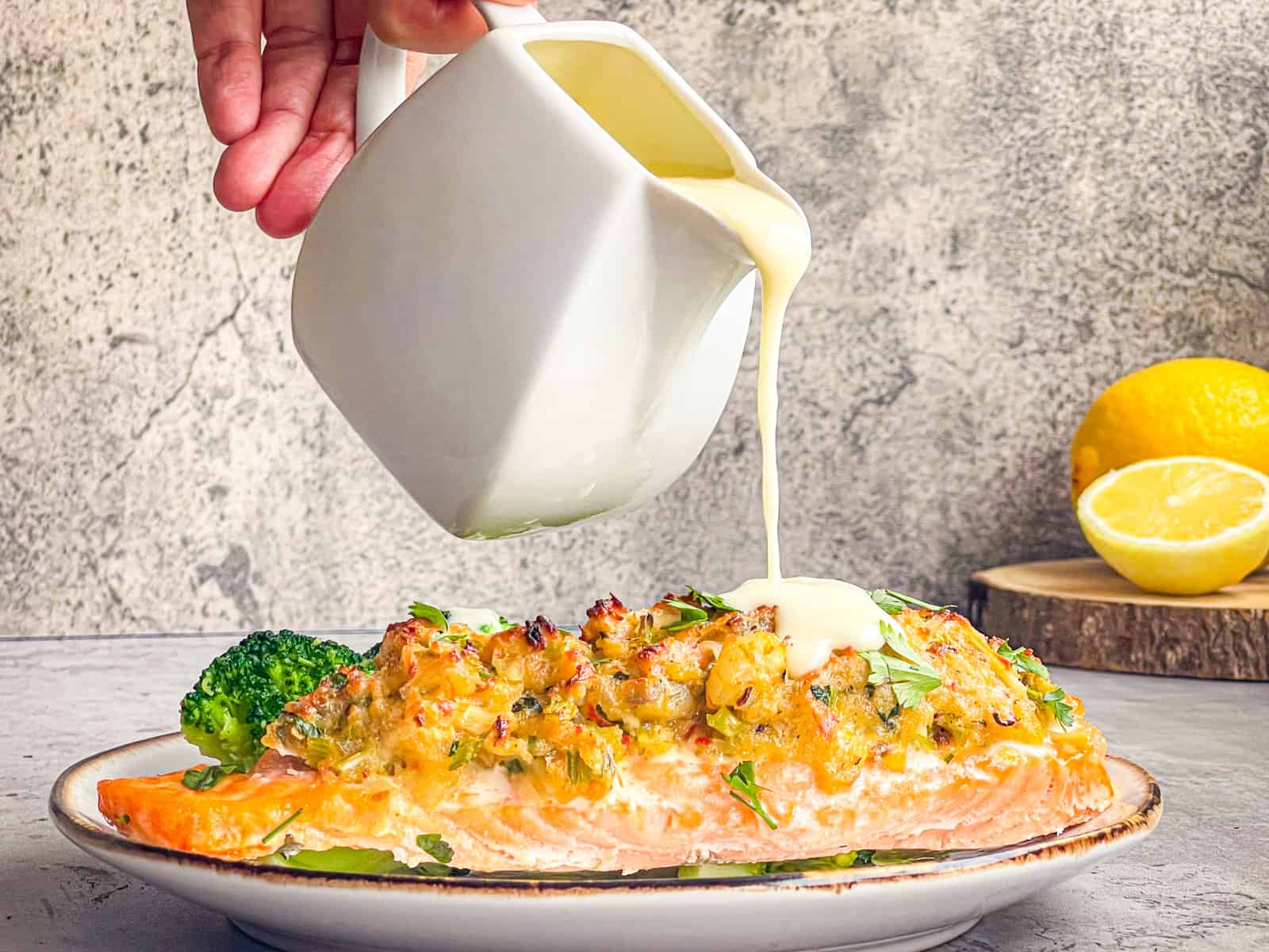 Sauce drizzling over stuffed salmon fillet.