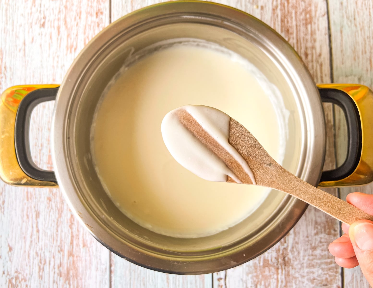 sauce on a spoon with a finger mark dragged through the sauce showing the proper consistency.