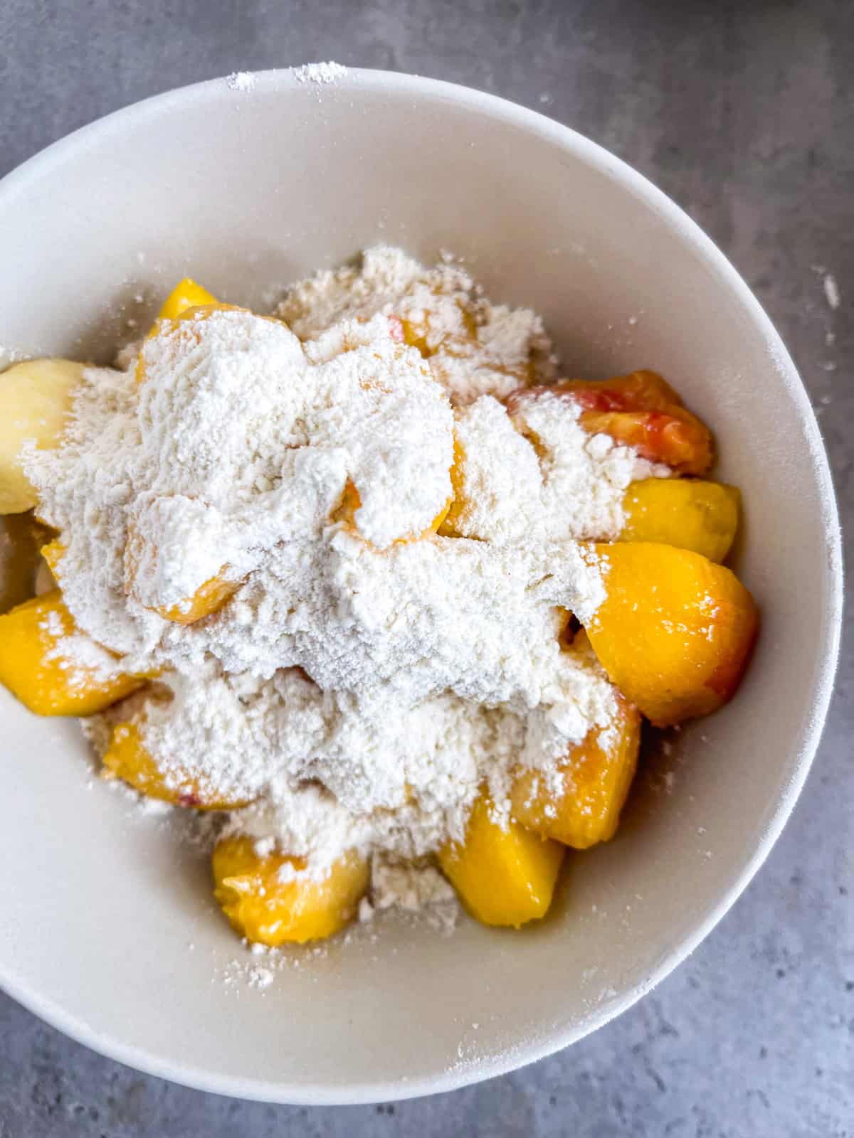 Powdered sugar on top of peaches.