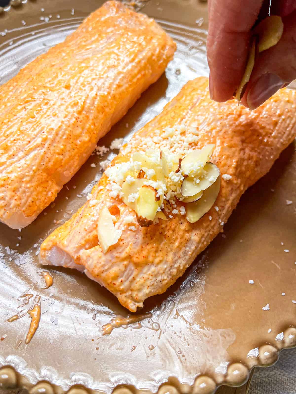 Halibut Fillets sprinkled with sliced almonds and grated parmesan.