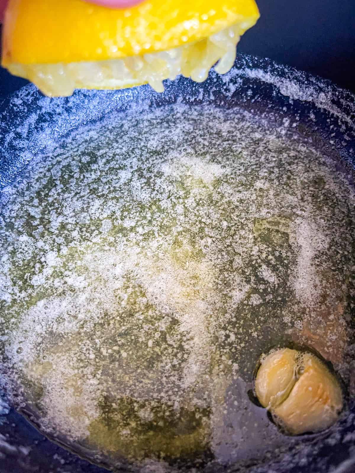 squeezing lemon juice into butter sauce.