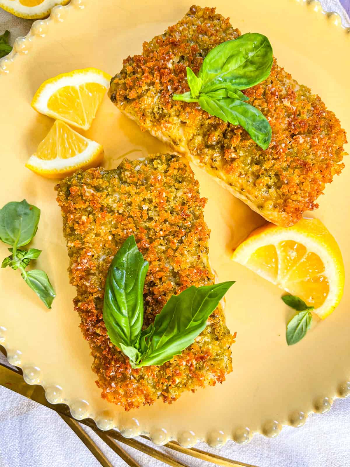 2 piece of pesto bread crumb Mahi Mahi garnished on a yellow plate.