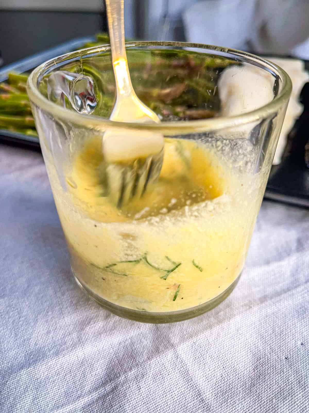 Garlic butter sauce stirred in a measuring cup.