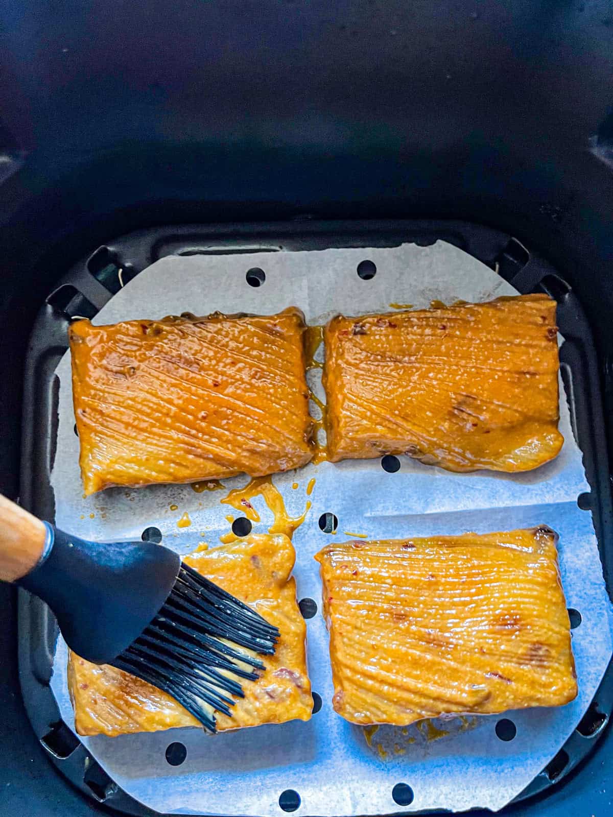 4 cod fillets in air fryer brushed with miso marinade.