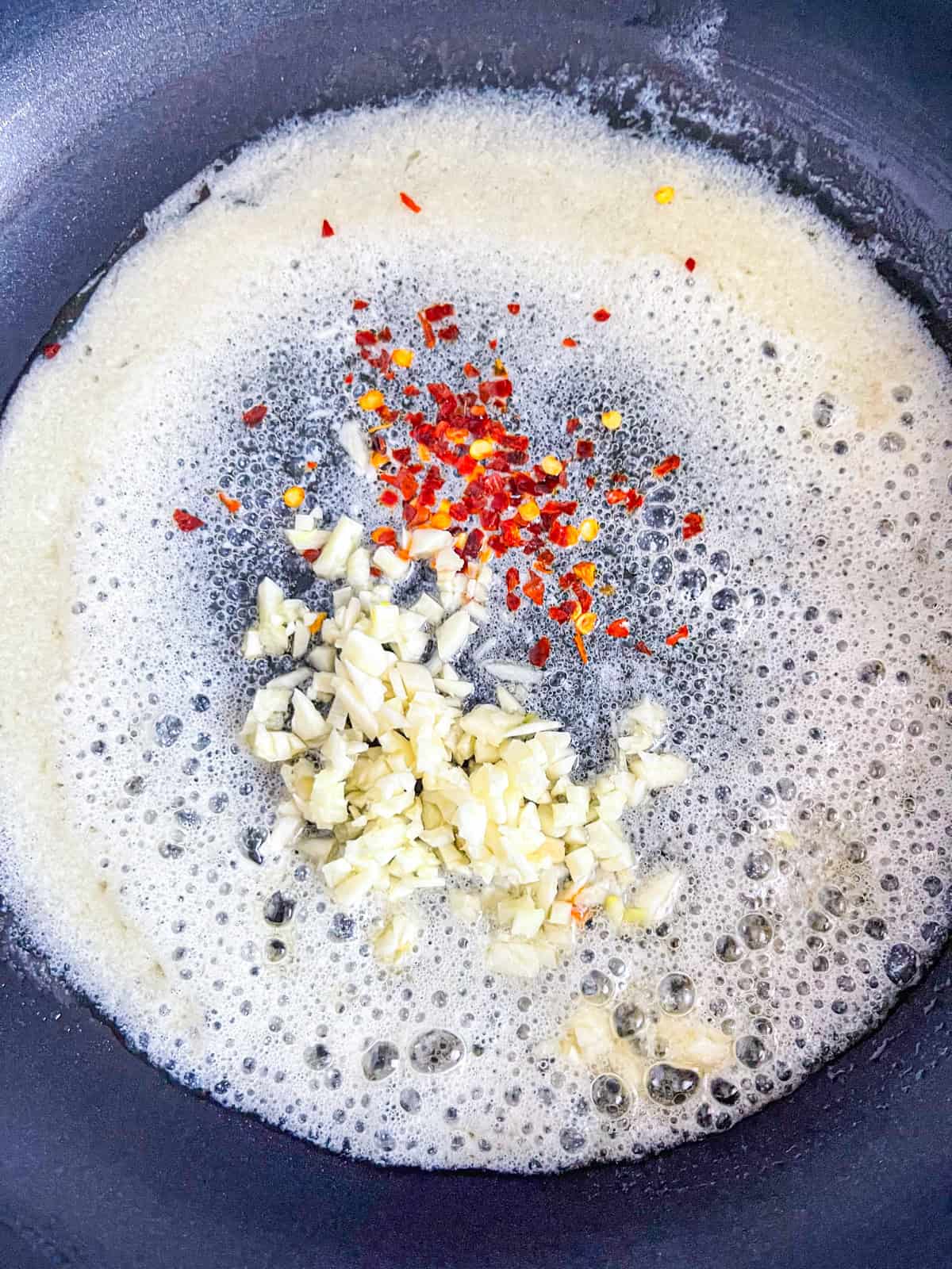 Butter, garlic and crush red pepper cooked in a skillet