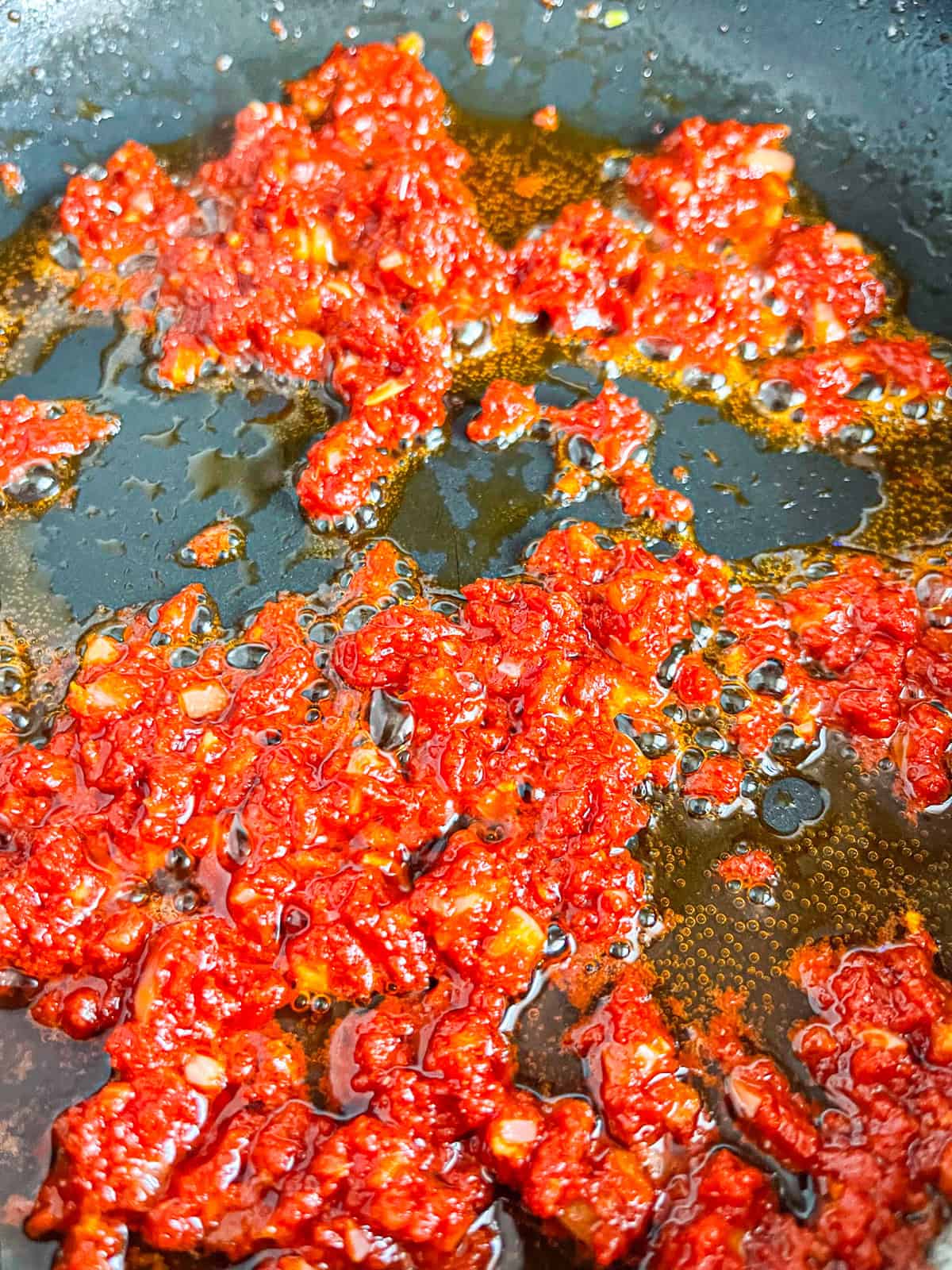 tomato pasta being cooked in a skillet.