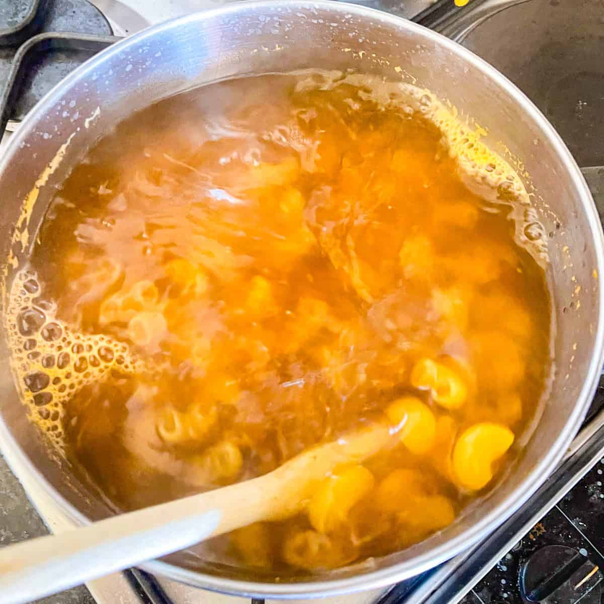 Pasta cooking in a pot of boiling water.