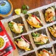 Sushi hand roll laid across the table next to can of tuna and edamame