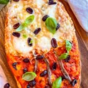 Anchovy Pizza on a board .