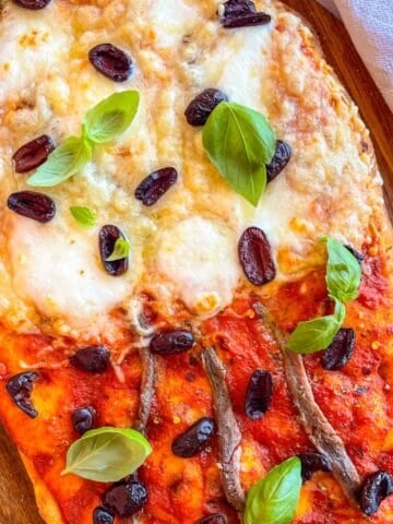 Anchovy Pizza on a board .