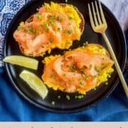 2 toast with Smoked salmon and scrambled eggs on a black plate.