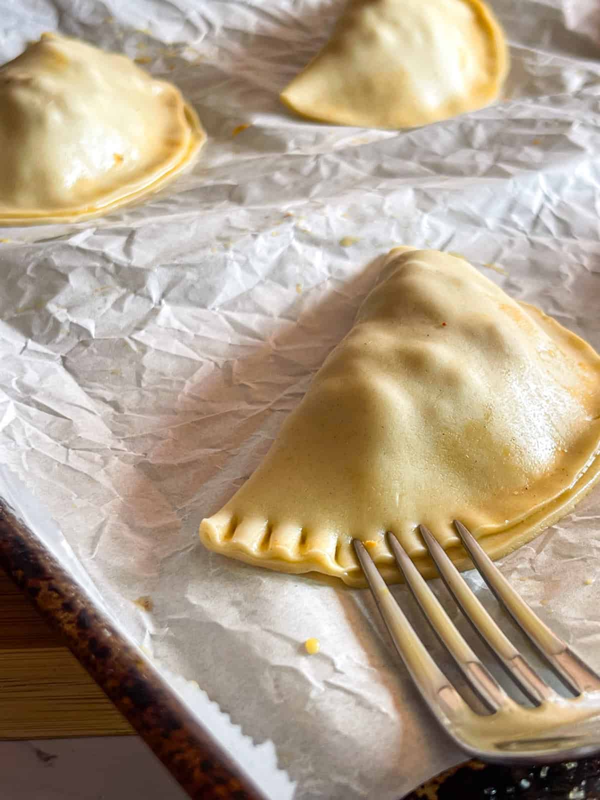 sealing empanadas with the tines of a fork.