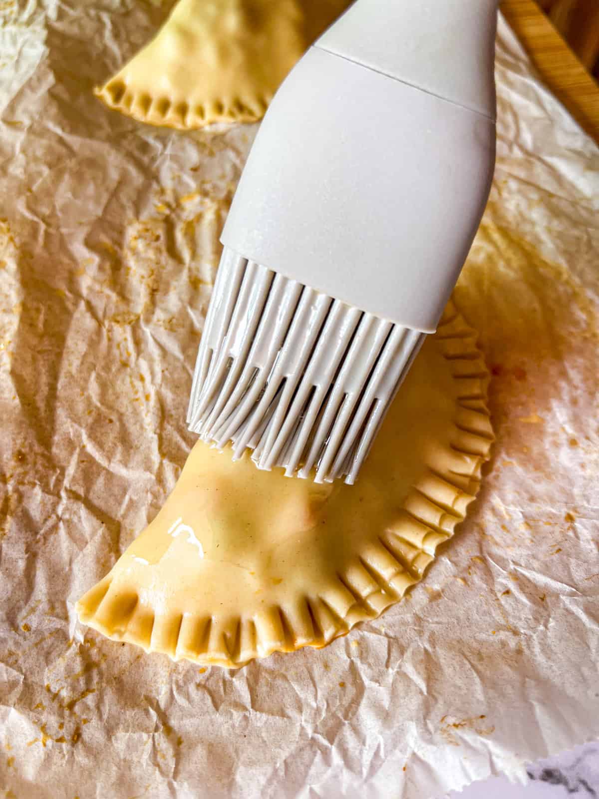 brushing tuna pie with oil before baking.