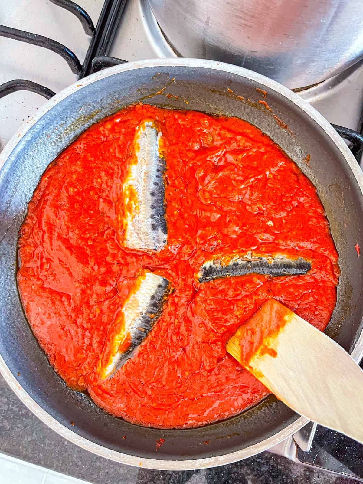 Sardine and marinara cooked in a skillet.