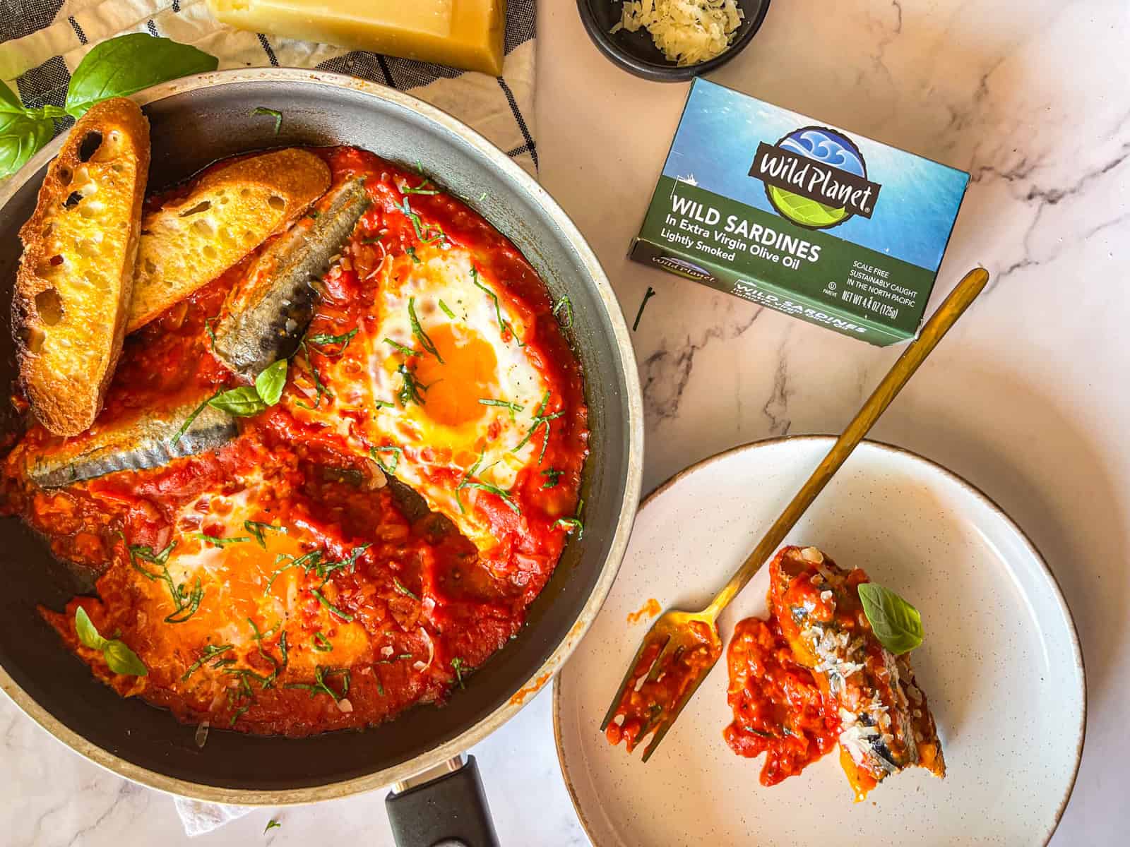 skillet of saucy breakfast sardines with toasted bread.