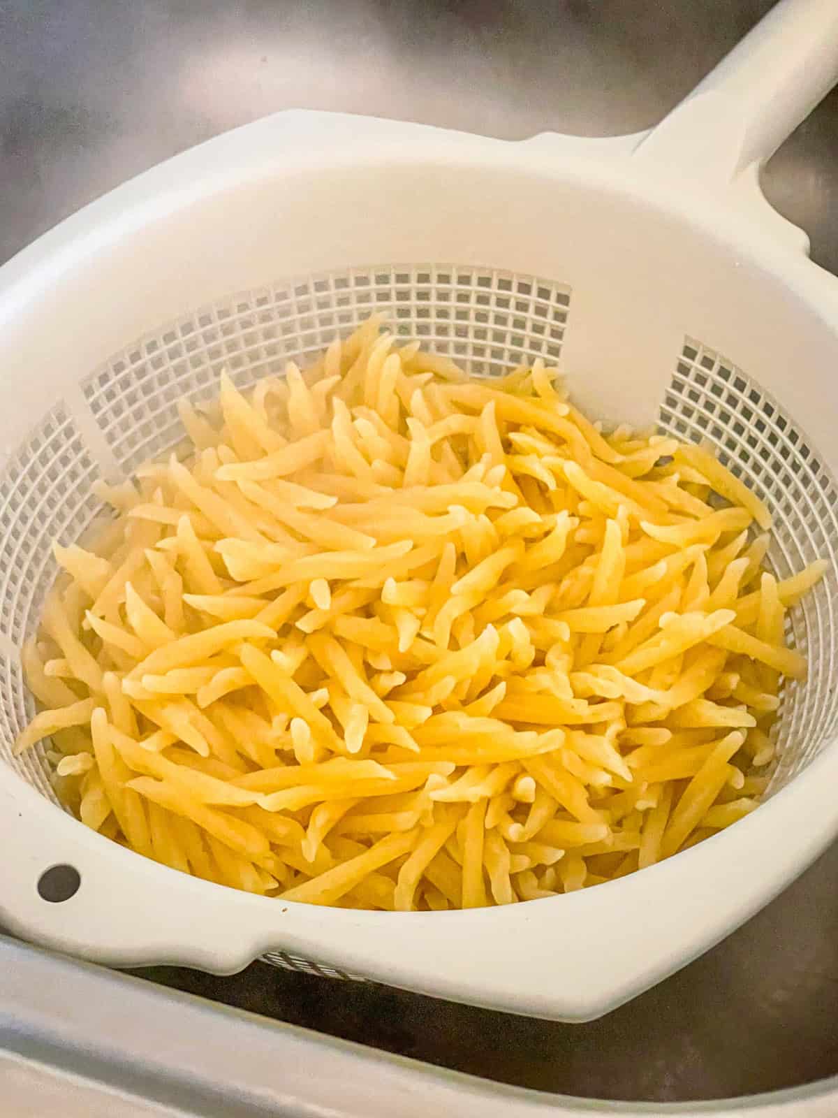 Cooked pasta in colander.