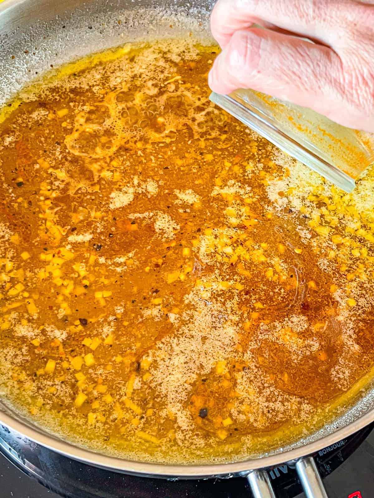 Shrimp stock added to skillet.