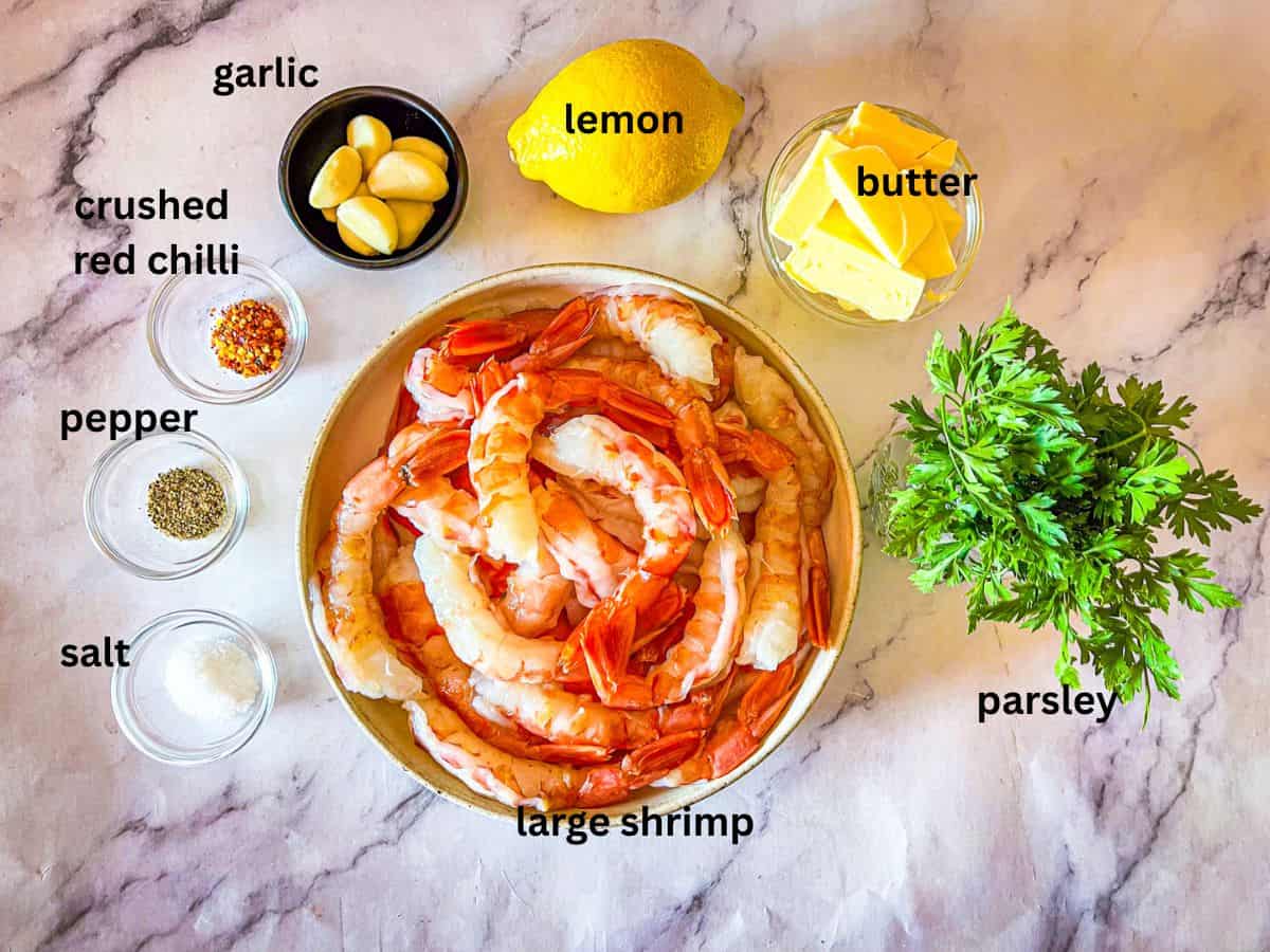 Ingredients for shrimp scampi without wine recipe laid out on a table and labeled.