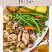 Grilled calamari on a platter served with potatoes and vegetables.