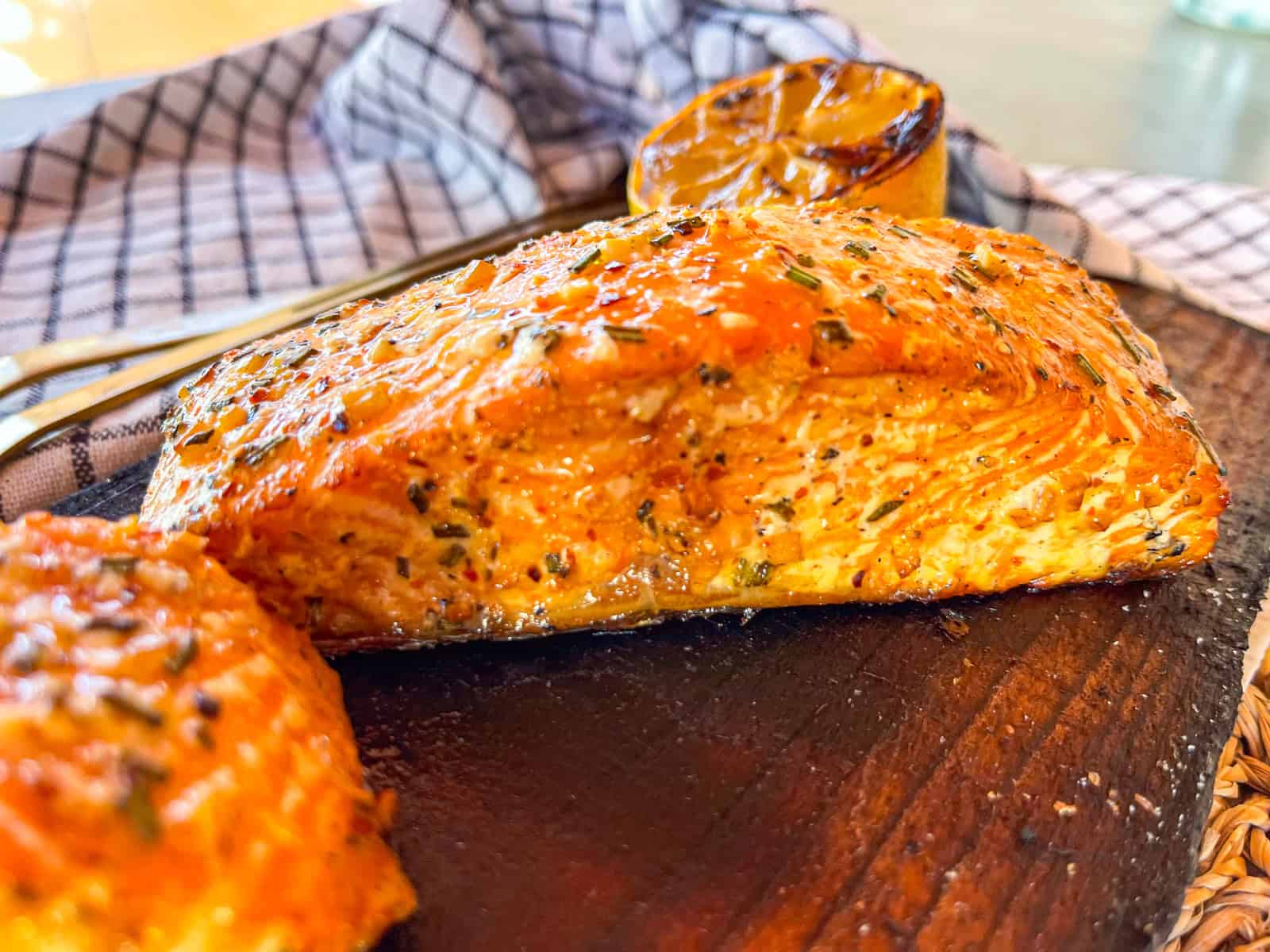 two salmon fillets on a grilled wooden plank.