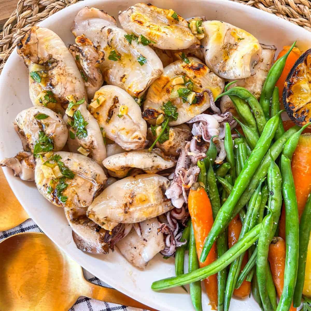 platter of grilled squid from the BBQ drizzled in garlic herb sauce.