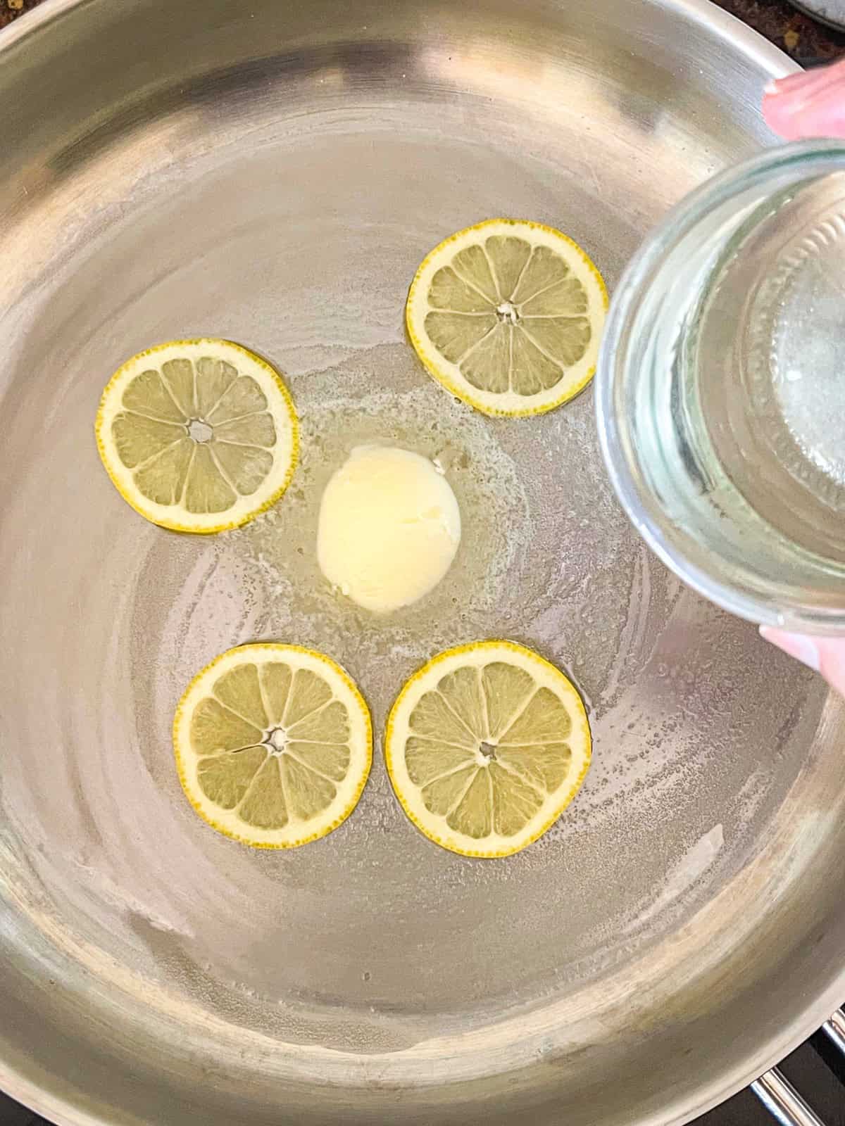 Wine added to butter , lemon in a pan.