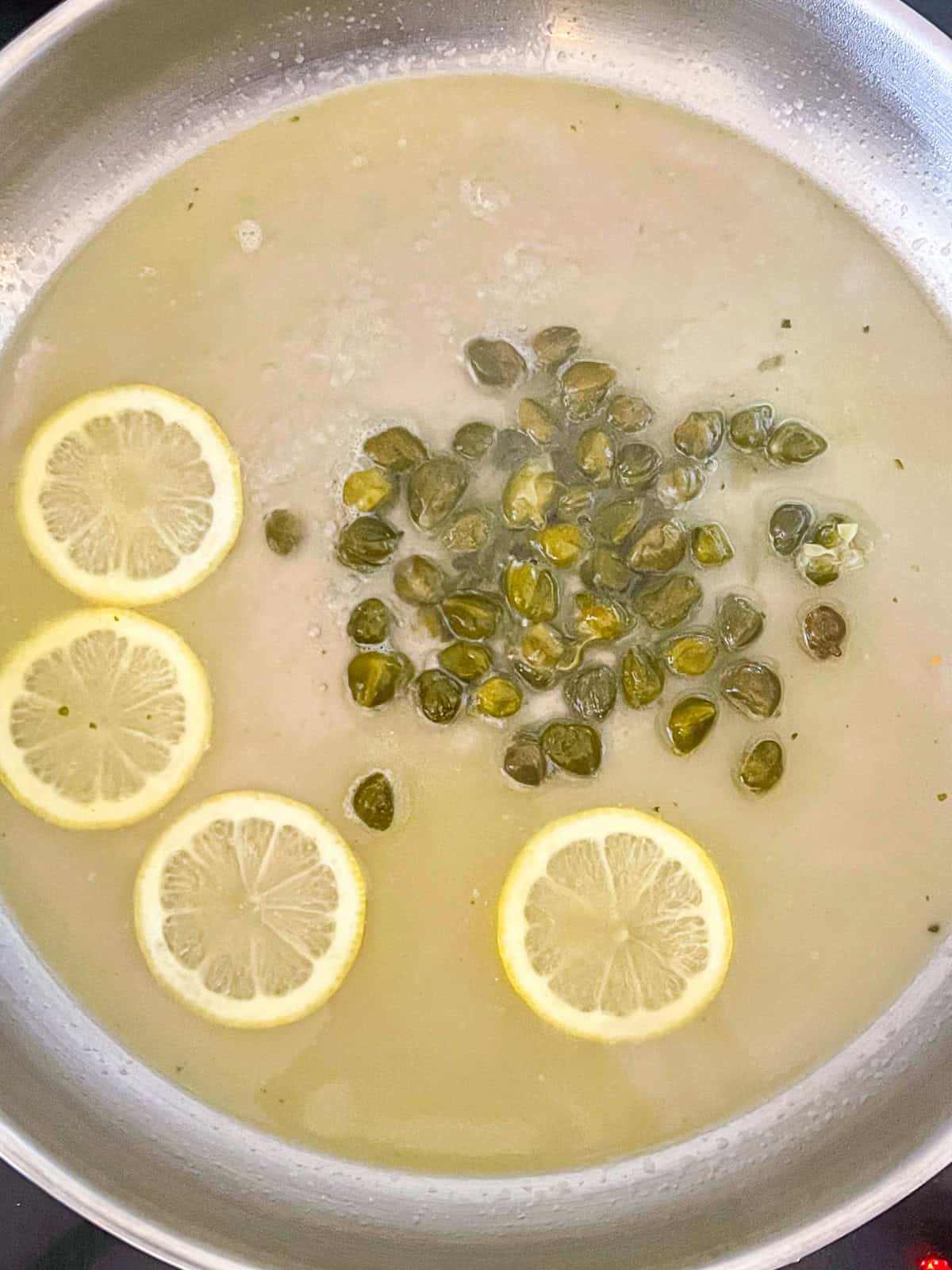 Capers, lemons and white wine sauce pan.