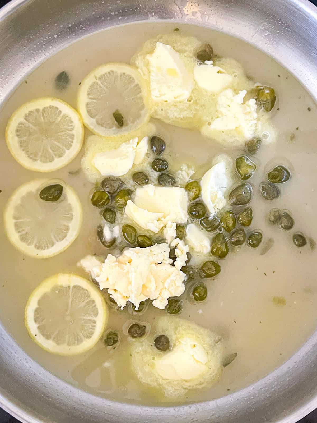 Lemon butter sauce with capers in a pan.