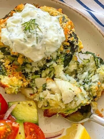 fish cake cut open on a plate and garnished with creamy sauce.