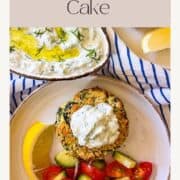 Piece of fish cake with tzatziki on a plate with vegetables.