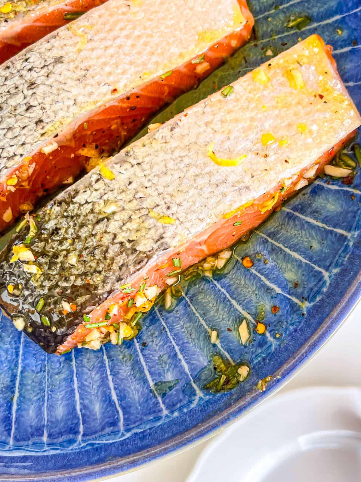 Salmon with marinate in a blue bowl