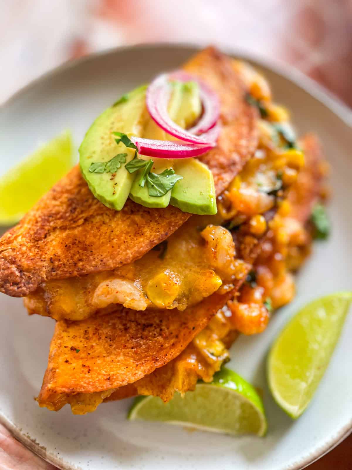 two quesadillas stacked on a white plate.