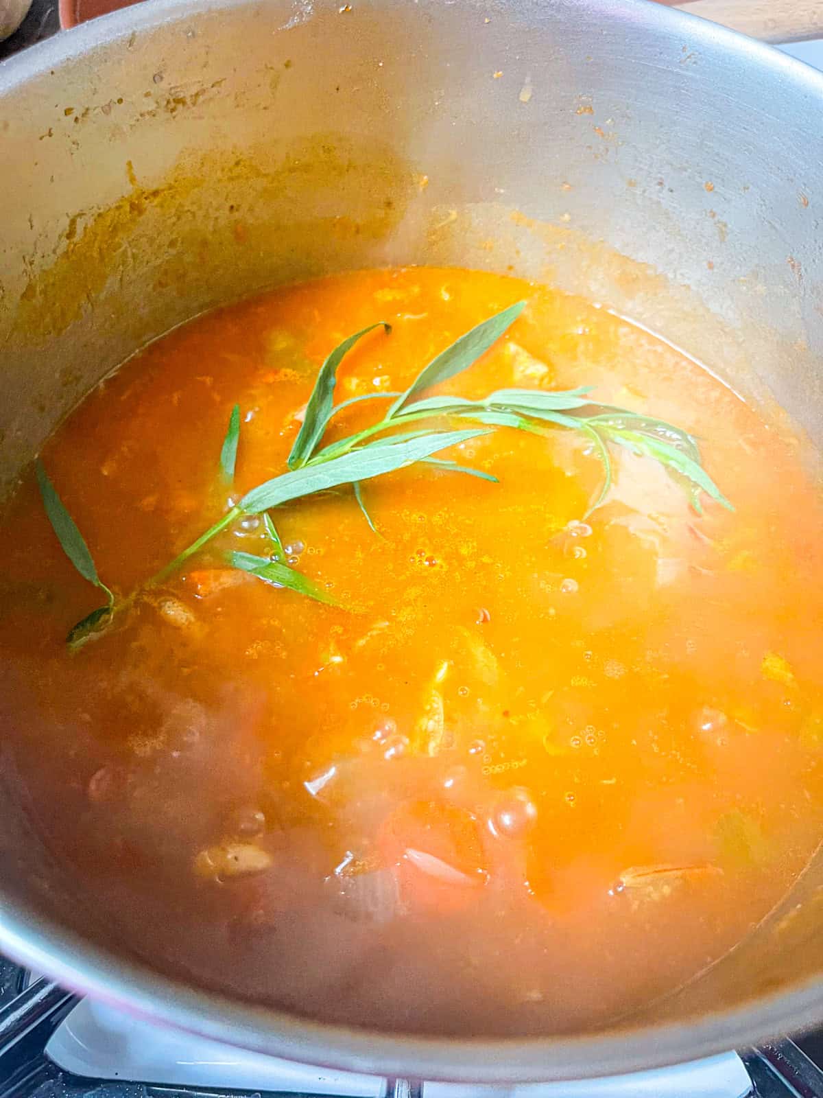 Stock with tarragon in a pot.