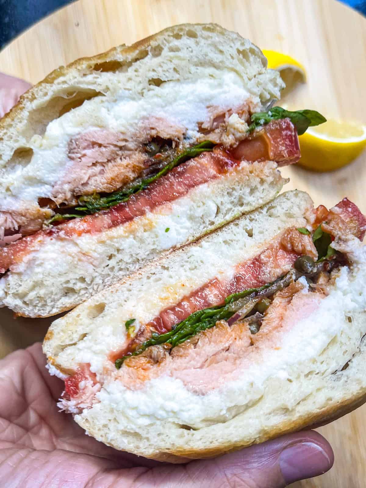 Smoked salmon Sandwich stacked on board.