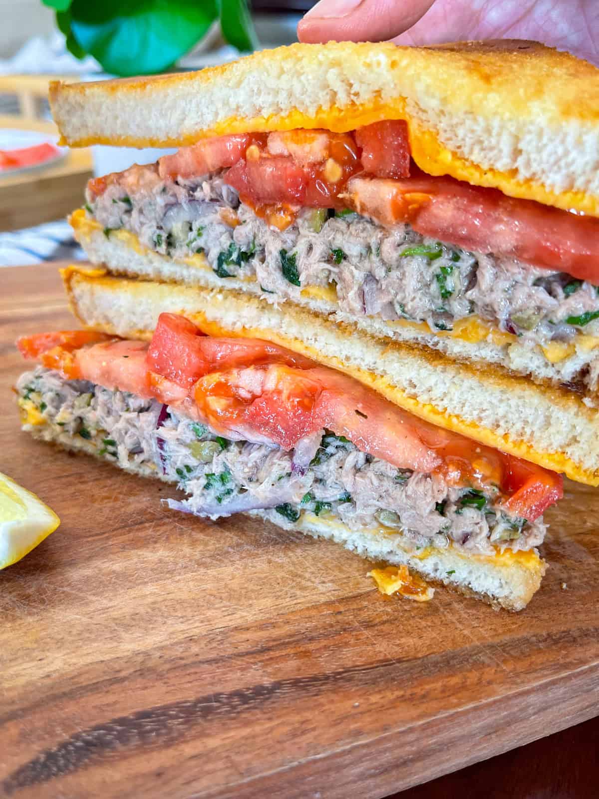 tuna melt stacked on a board.