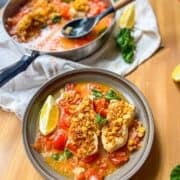 Poached fish in spicy tomato broth in a bowl and a pan.